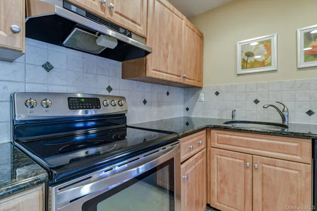 a kitchen with stainless steel appliances granite countertop a stove and a microwave