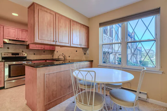a kitchen with granite countertop a stove a sink and a wooden cabinets