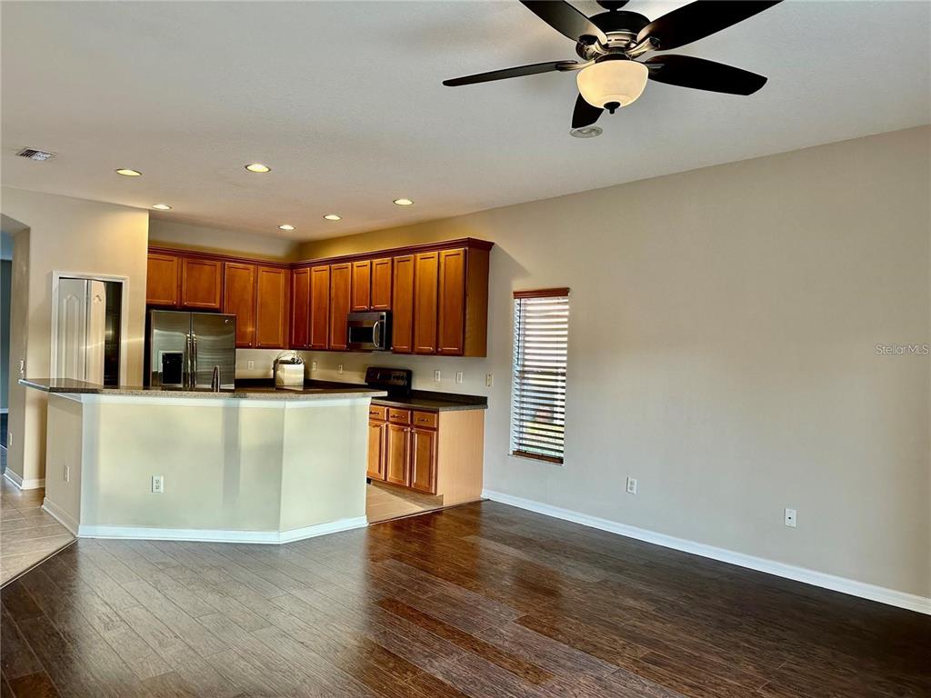 9249 Edistro Place New Port Richey, FL 34654 - Photo 11 of 82 a view of kitchen with stainless steel appliances granite countertop a refrigerator a stove top oven a sink and dishwasher with wooden floor