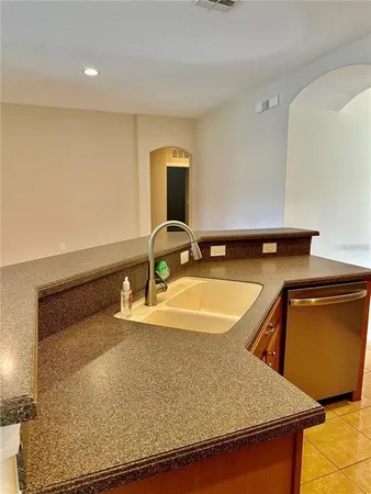 an empty room with wooden floor cabinet and windows