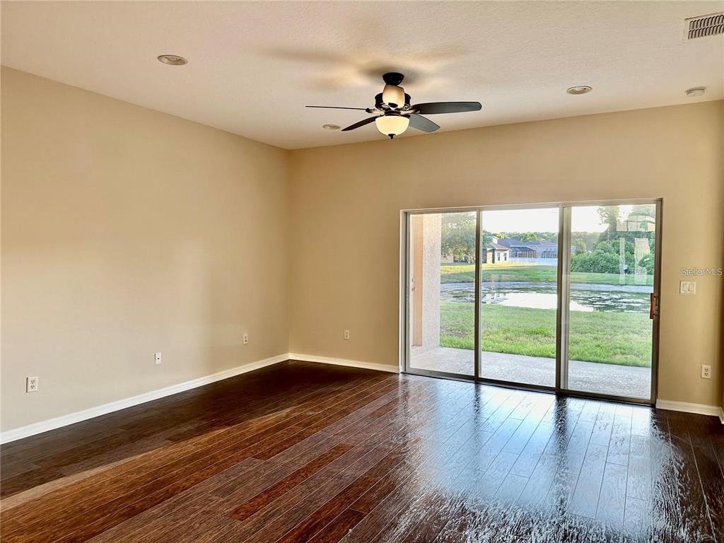 9249 Edistro Place New Port Richey, FL 34654 - Photo 21 of 82 a view of an empty room with wooden floor and a window