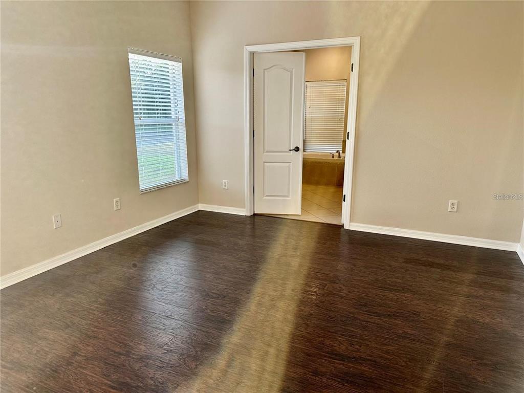 9249 Edistro Place New Port Richey, FL 34654 - Photo 23 of 82 an empty room with wooden floor and windows