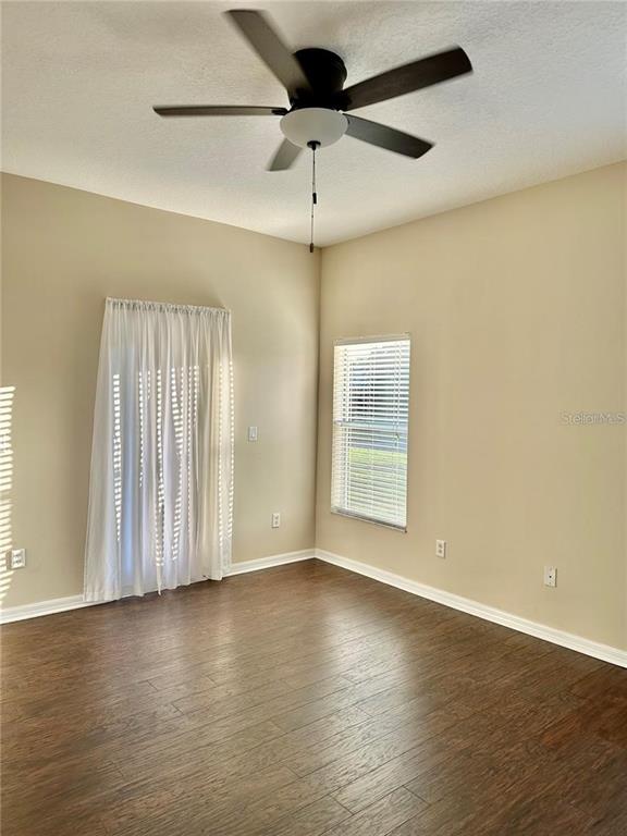 9249 Edistro Place New Port Richey, FL 34654 - Photo 30 of 82 an empty room with wooden floor fan and windows