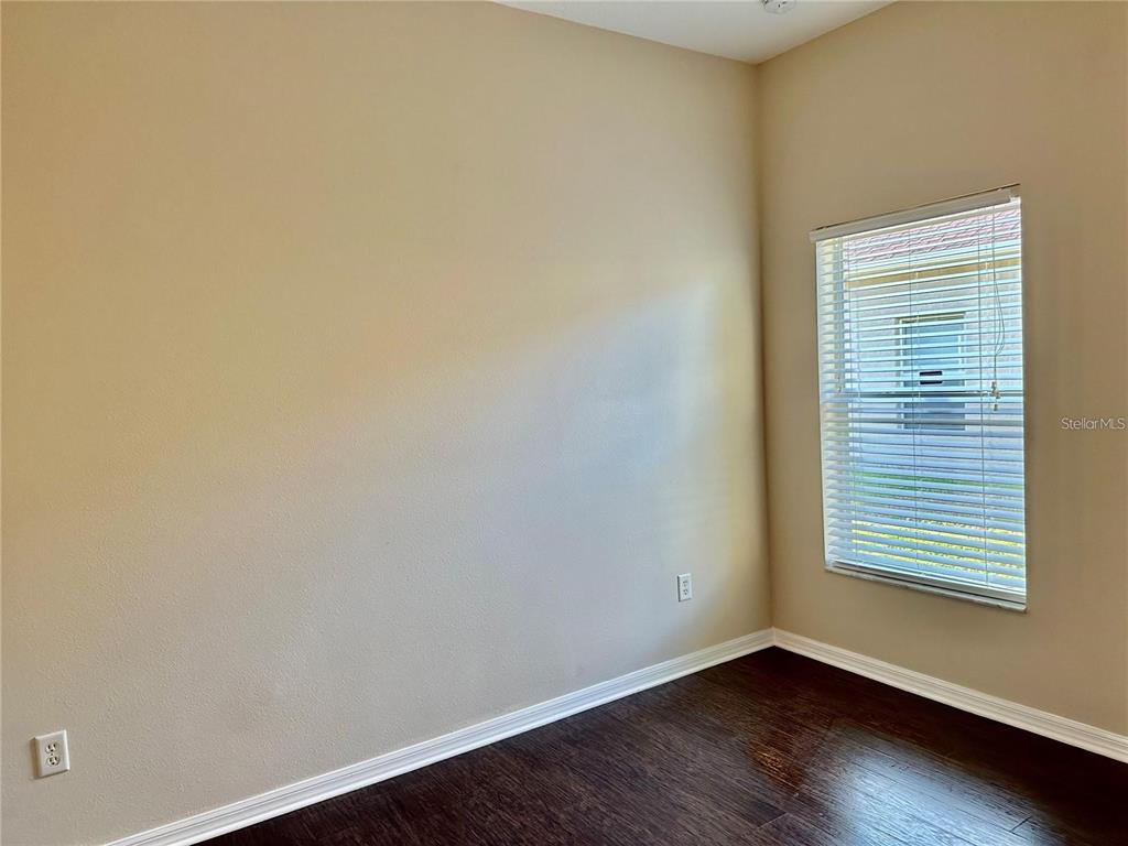 9249 Edistro Place New Port Richey, FL 34654 - Photo 50 of 82 a view of an empty room with wooden floor and a window