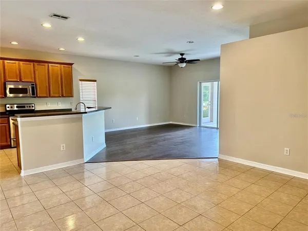 a view of kitchen with stainless steel appliances granite countertop a refrigerator a stove top oven a sink and dishwasher with wooden floor