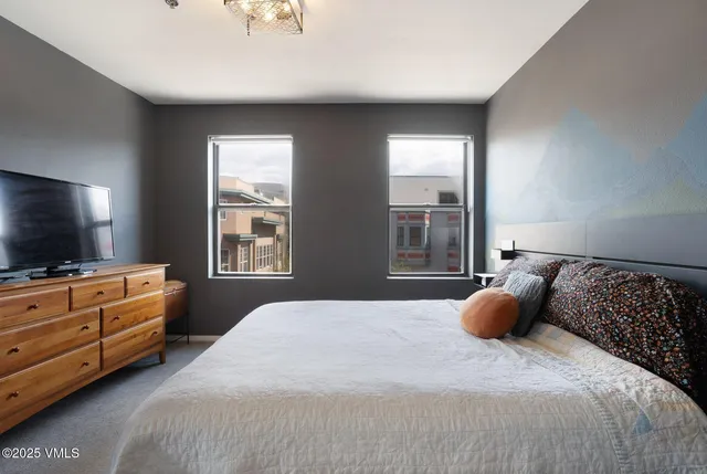 a bedroom with a bed and flat screen tv