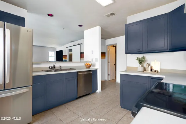 a kitchen with stainless steel appliances a sink a stove a refrigerator and cabinets
