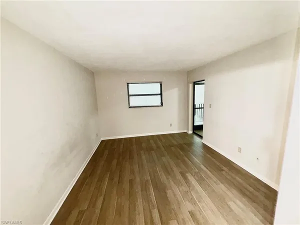 a view of a room with wooden floor and window