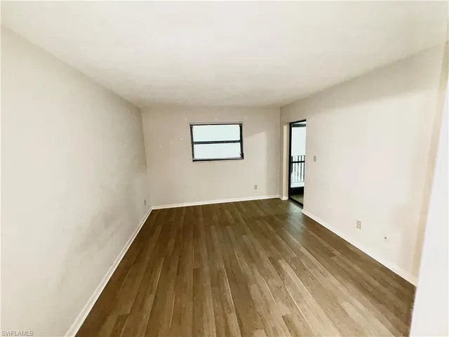 a view of a room with wooden floor and window