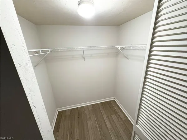 a view of walk in closet with empty racks