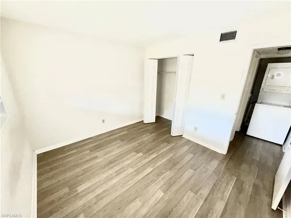 an empty room with wooden floor and entrance