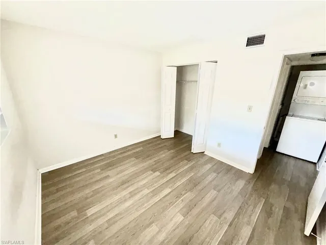 an empty room with wooden floor and entrance