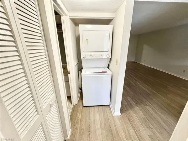 a utility room with wooden floor washer and dryer