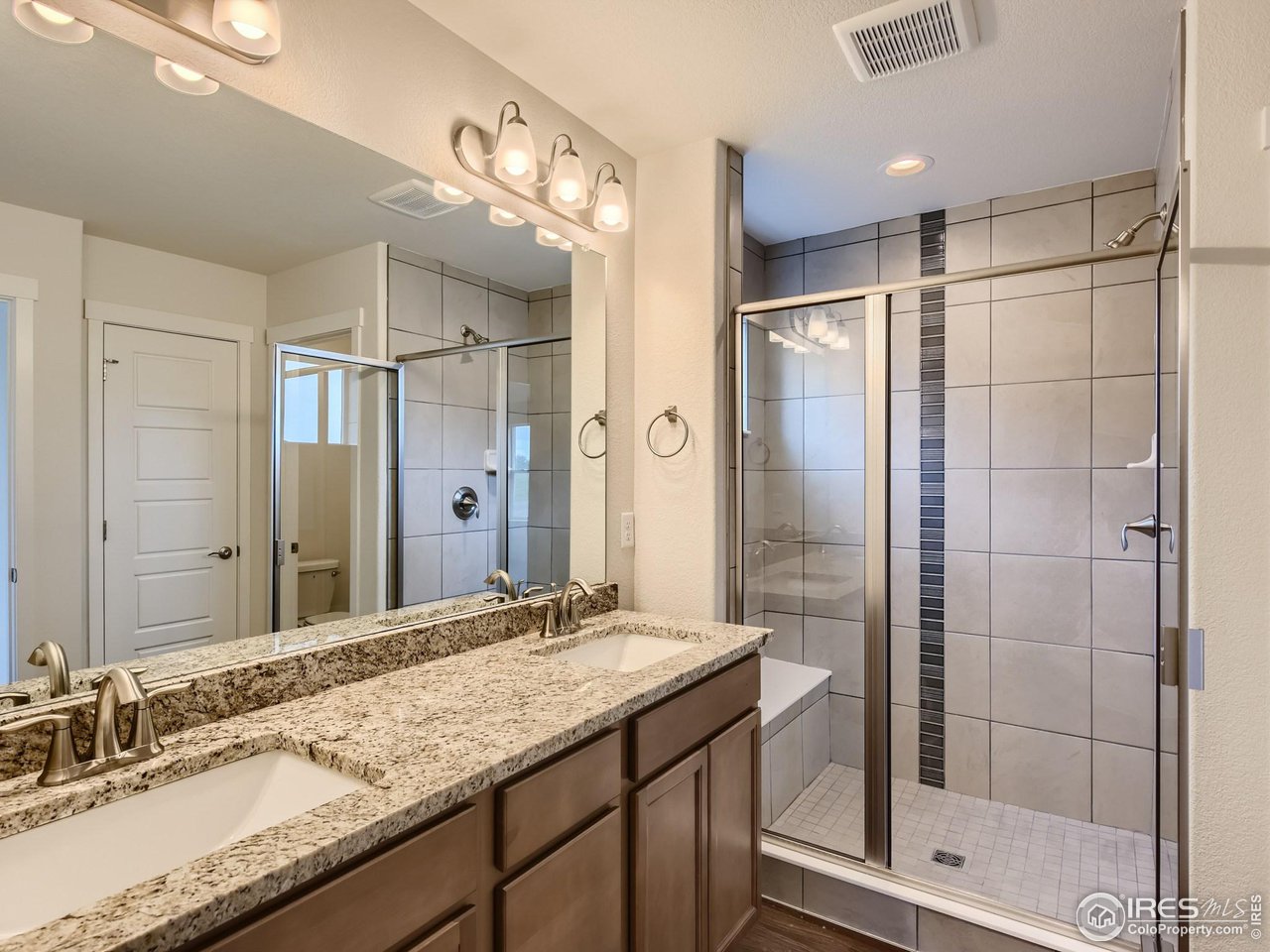 2538 Doe Rdg Way Johnstown, CO 80534 - Photo 18 of 28 a bathroom with a granite countertop sink mirror and shower