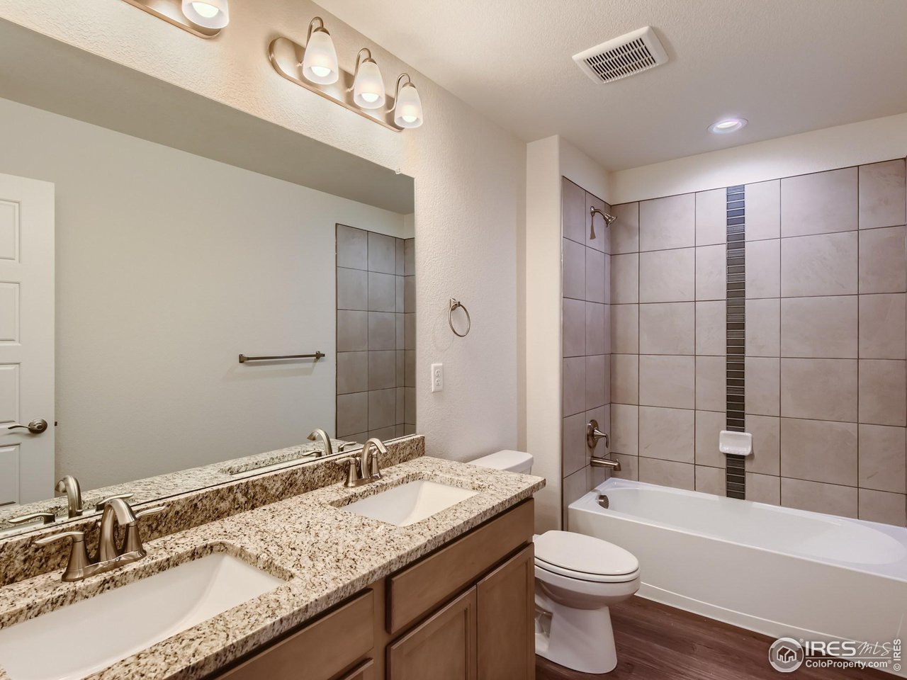 2538 Doe Rdg Way Johnstown, CO 80534 - Photo 22 of 28 a bathroom with a granite countertop sink a toilet a mirror a bathtub and shower