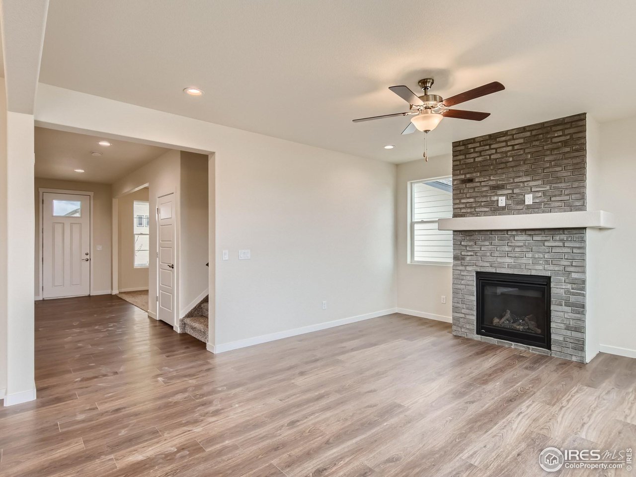 2538 Doe Rdg Way Johnstown, CO 80534 - Photo 6 of 28 a view of an empty room with wooden floor a fireplace and a window