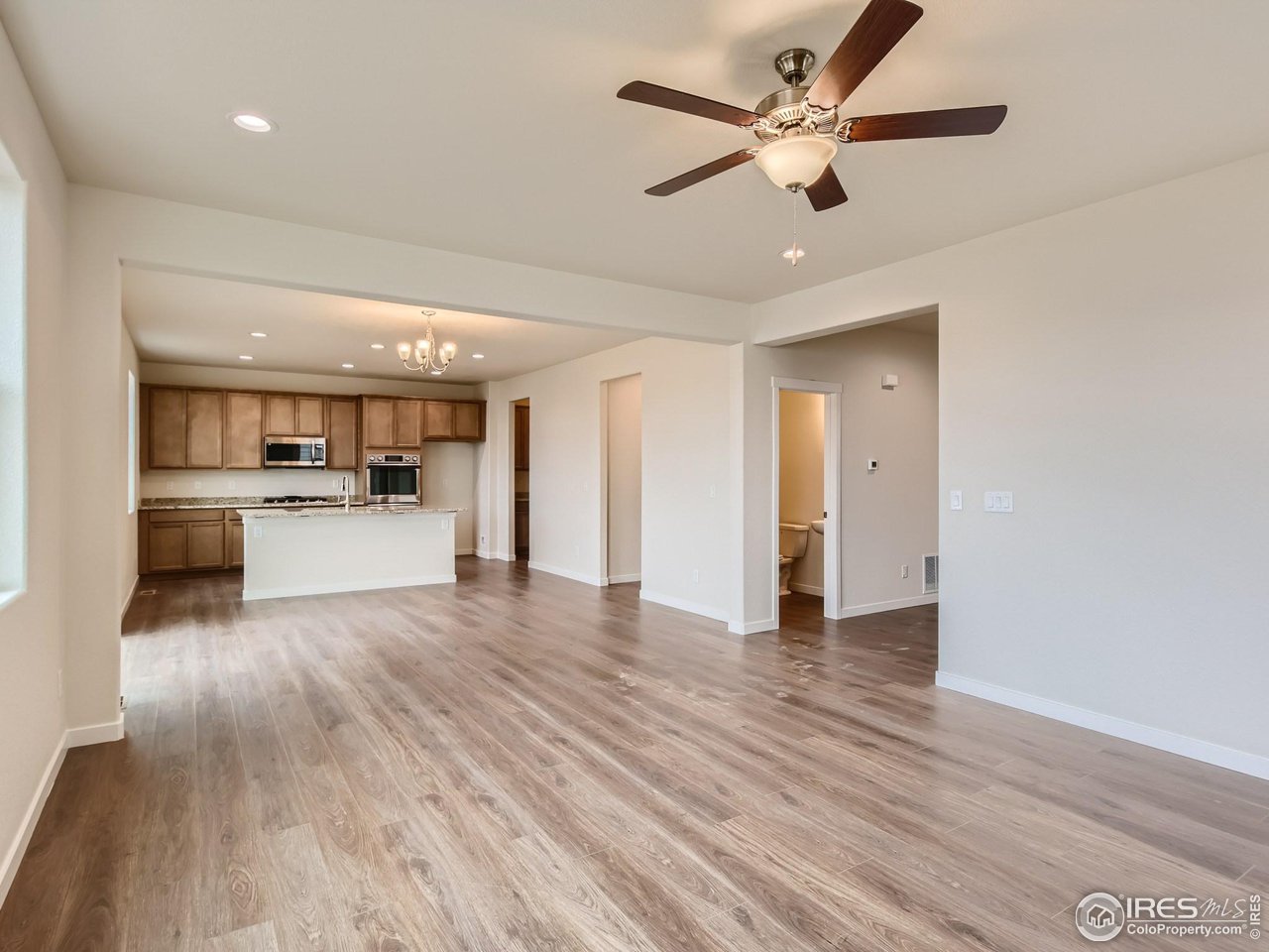 2538 Doe Rdg Way Johnstown, CO 80534 - Photo 7 of 28 a view of a kitchen with wooden floor and a ceiling fan