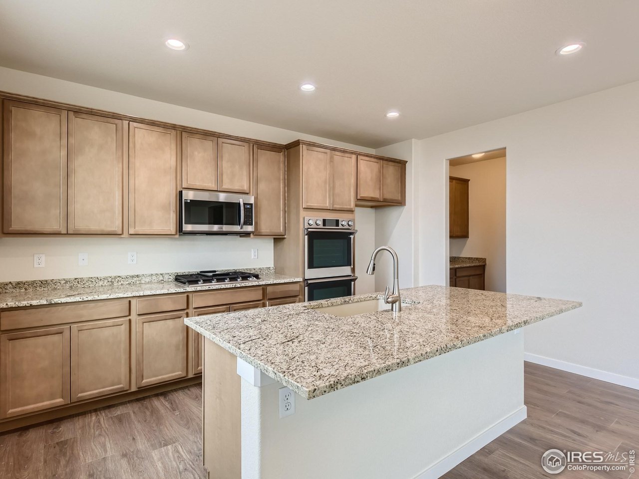 2538 Doe Rdg Way Johnstown, CO 80534 - Photo 10 of 28 a kitchen with granite countertop a stove top oven sink and cabinets