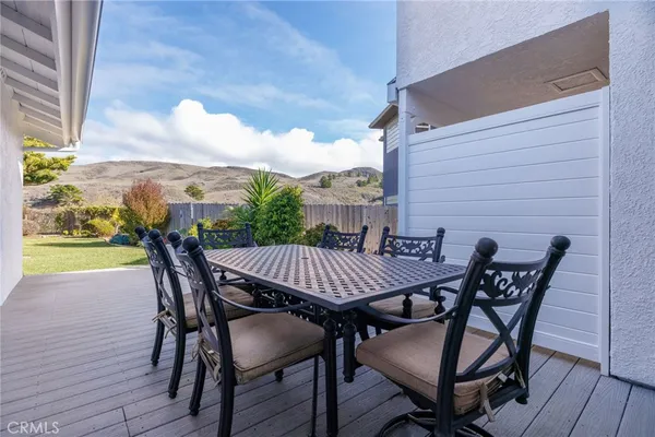 a view of a patio with table and chairs with wooden floor and fence