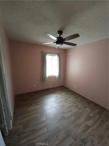 an empty room with a window and a ceiling fan