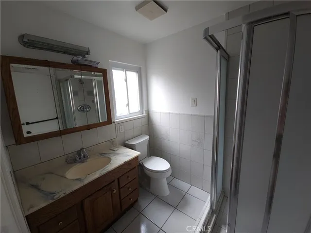 a bathroom with a granite countertop toilet sink and mirror
