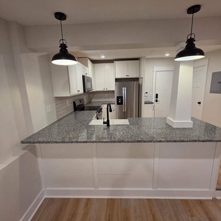 a kitchen with sink cabinets and wooden floor