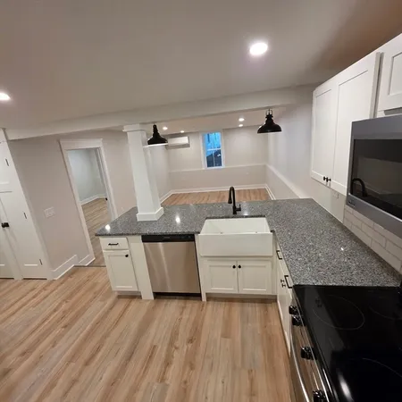 a large kitchen with stainless steel appliances granite countertop a stove and a refrigerator