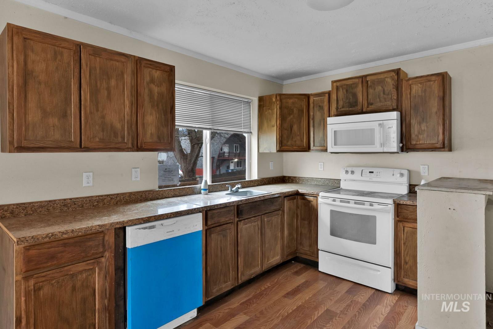 4715 West Reeves Street Coeur D'Alene, ID 83814 - Photo 9 of 24 Kitchen with white appliances, dark wood-style floors, and dark countertops