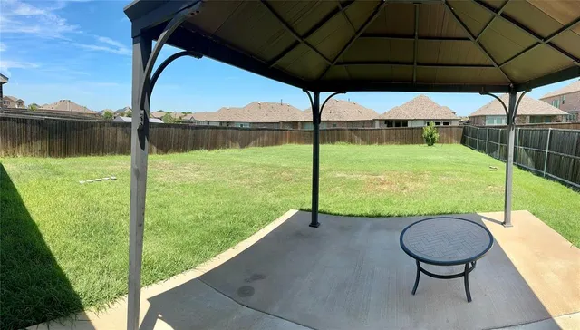a view of a wooden deck with a table and chairs under an umbrella