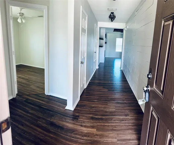 a view of a hallway with wooden floor and staircase