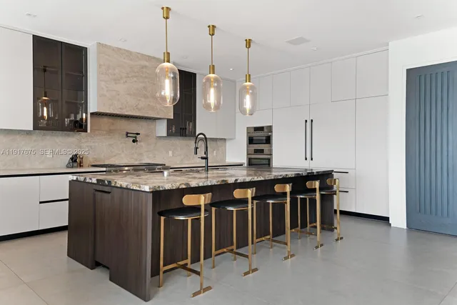 a large kitchen with kitchen island a counter top space a sink stainless steel appliances and cabinets
