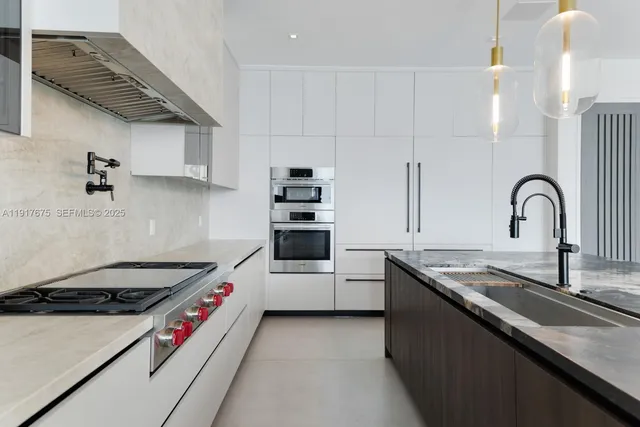 a kitchen with stainless steel appliances kitchen island granite countertop a table and chairs