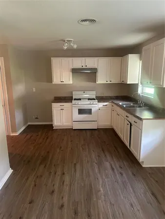 a white kitchen with granite countertop stainless steel appliances