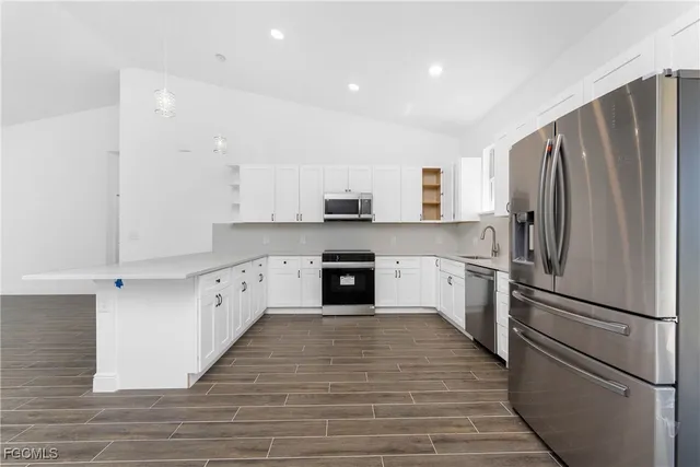 a kitchen with granite countertop a refrigerator oven a sink and dishwasher