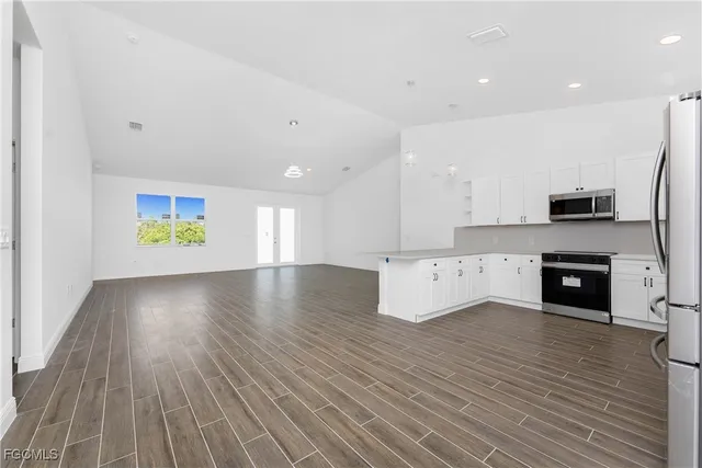 a view of an empty room with a fireplace and a window