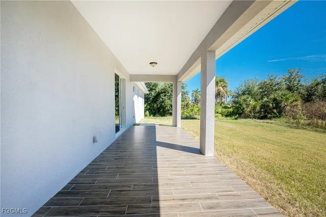 a view of a patio with wooden floor and floor to ceiling window