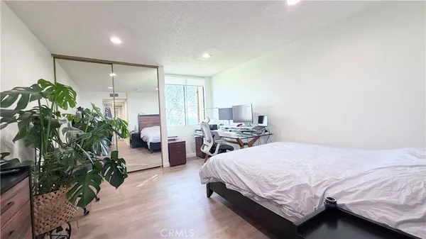 a bedroom with a bed and a potted plant