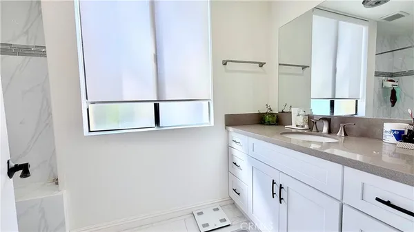 a bathroom with a granite countertop sink and a mirror