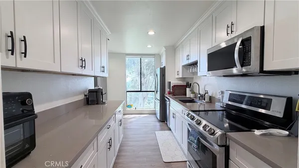 a kitchen with stainless steel appliances a sink a stove a microwave and cabinets