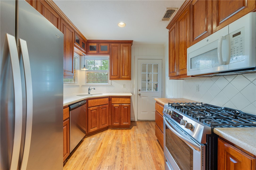 715 Inwood Drive Bryan, TX 77802 - Photo 23 of 34 a kitchen with stainless steel appliances granite countertop a stove a sink dishwasher and a refrigerator