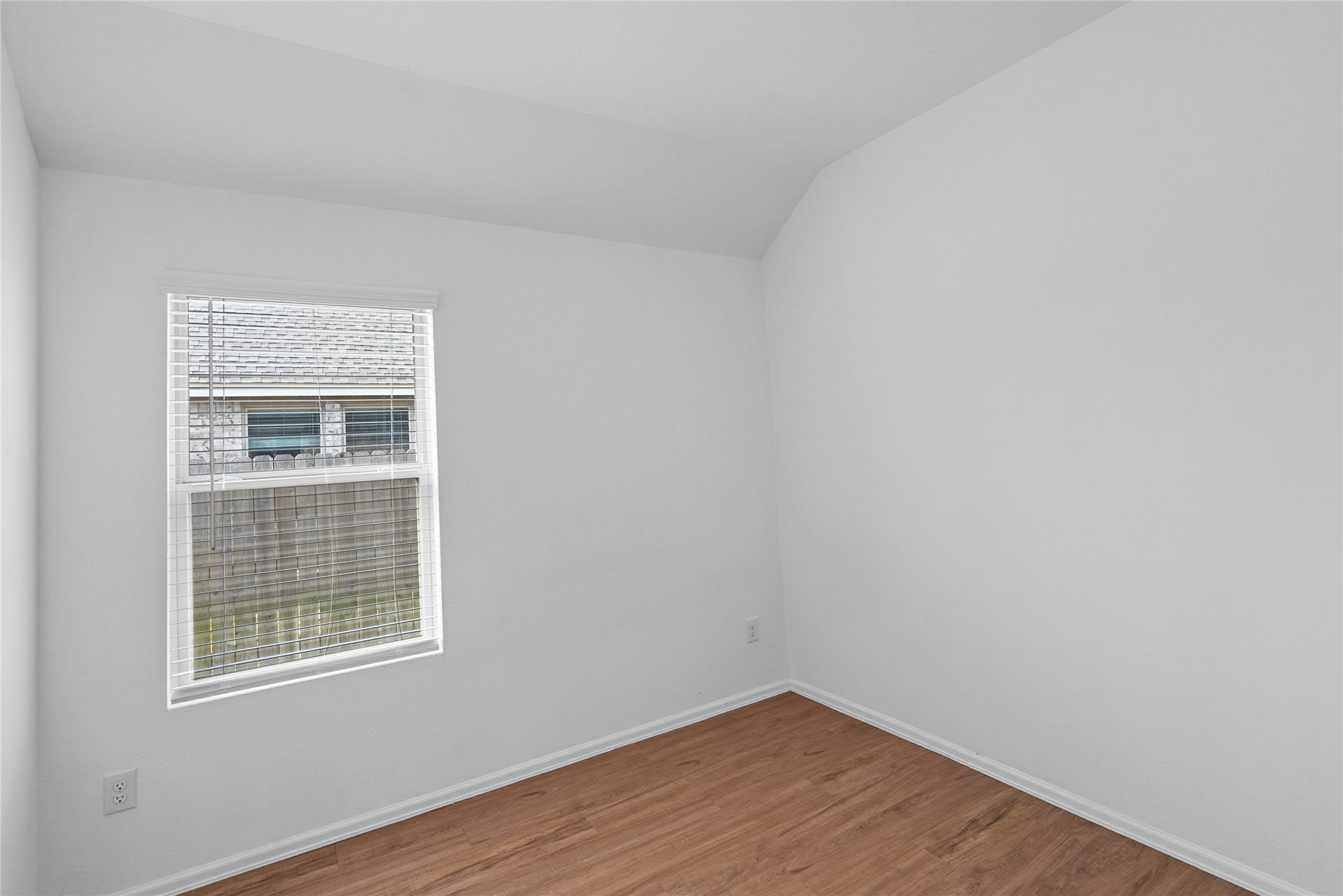 3705 Paloma Fls Lane Rosenberg, TX 77469 - Photo 15 of 27 Cozy secondary bedroom with a vaulted ceiling. A single window with white blinds brings in soft natural light.