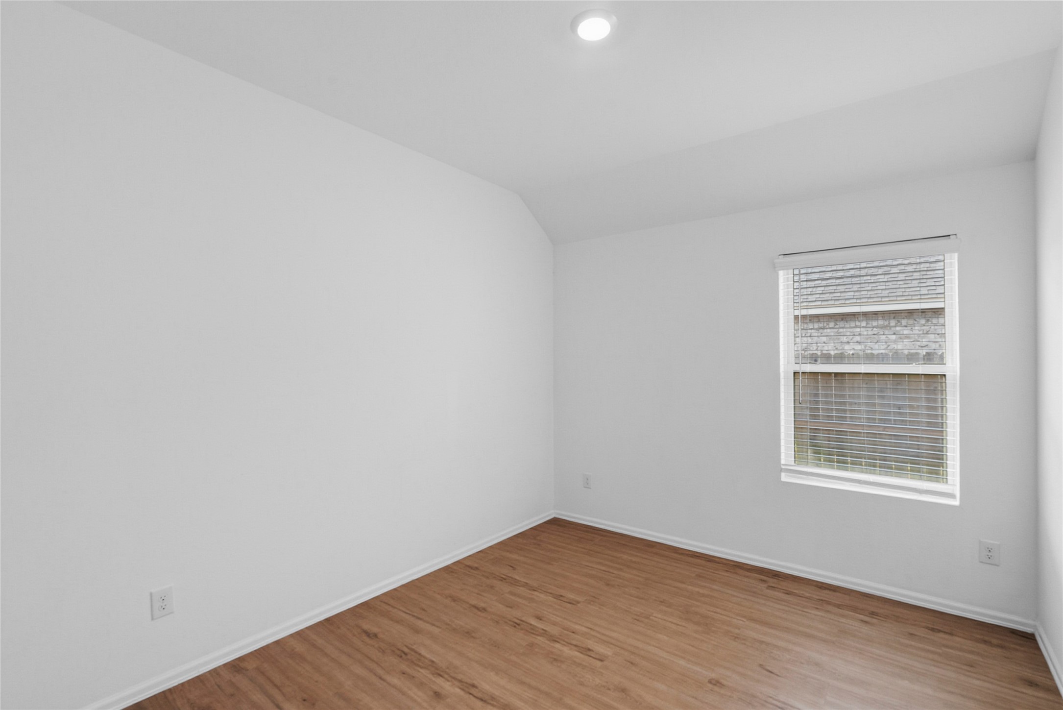 3705 Paloma Fls Lane Rosenberg, TX 77469 - Photo 17 of 27 Simple, airy bedroom with a sloped ceiling. Backyard-facing window with blinds brings in natural light while keeping privacy.