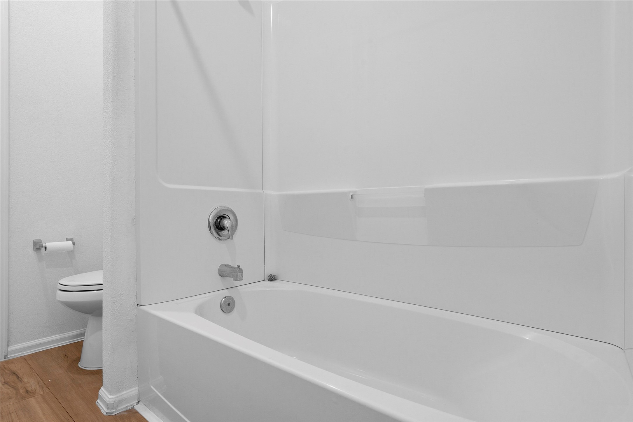 3705 Paloma Fls Lane Rosenberg, TX 77469 - Photo 21 of 27 Clean tub-and-shower setup with a smooth surround and built-in shelf for bath essentials. Separate toilet nook sits just outside the bathing area.