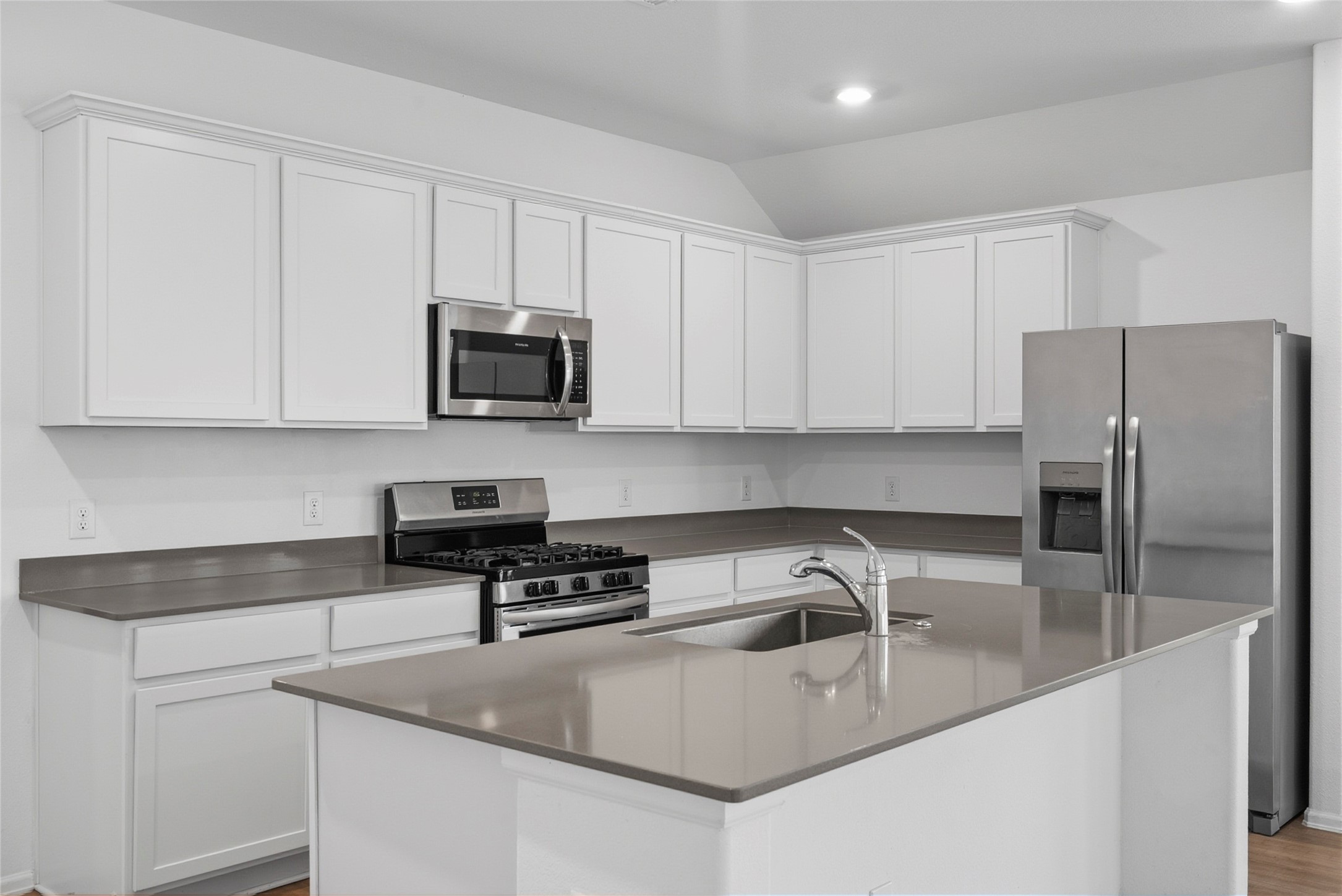 3705 Paloma Fls Lane Rosenberg, TX 77469 - Photo 5 of 27 Generous counter space and crisp white cabinetry create a clean, streamlined kitchen. The oversized island with an undermount sink pairs with stainless appliances for a polished finish.