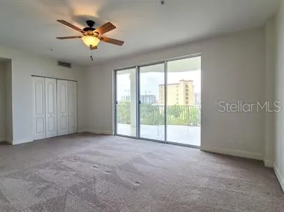 a view of an empty room and chandelier fan
