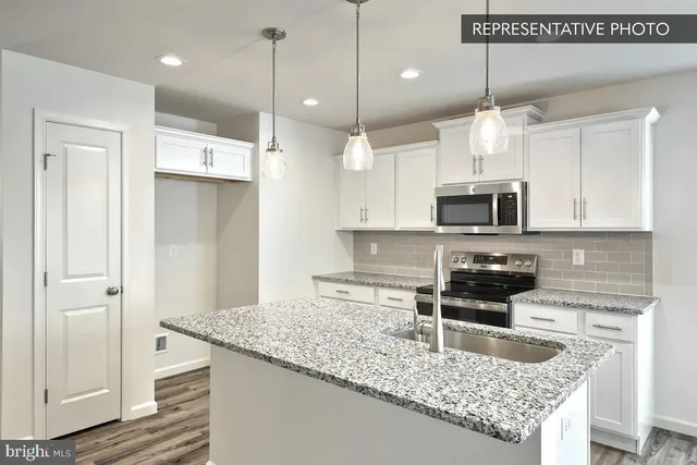a kitchen with stainless steel appliances granite countertop a sink a stove and a wooden cabinets