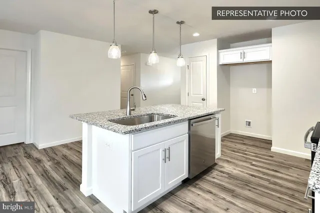 a kitchen with a sink cabinets and wooden floor