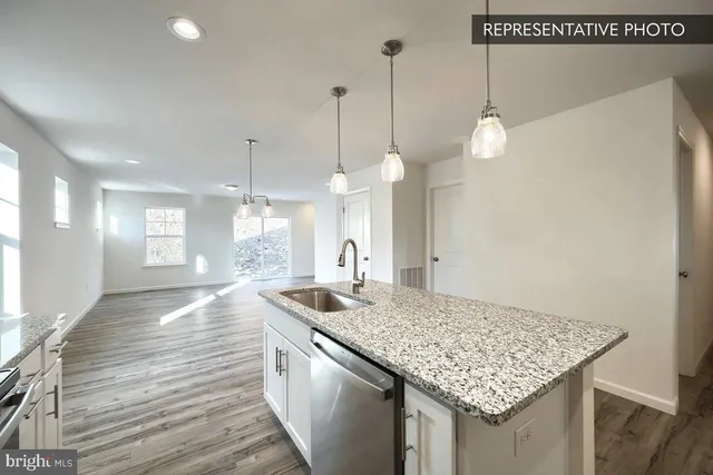 a kitchen with kitchen island a sink stove and wooden floor