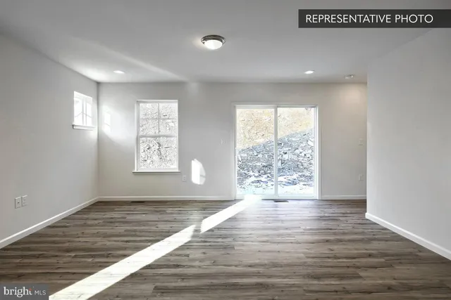 a view of a kitchen with white cabinets and wooden floor
