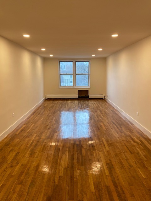 a view of a room with wooden floor and window